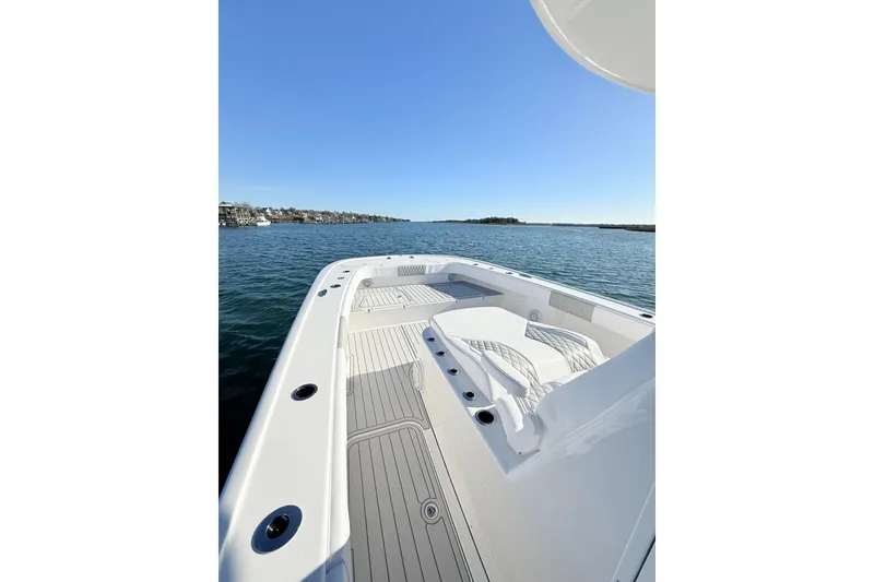 Slide: The Image of 2026 Tideline 365 Offshore boat on calm water, showcasing spacious deck and seating. - 61