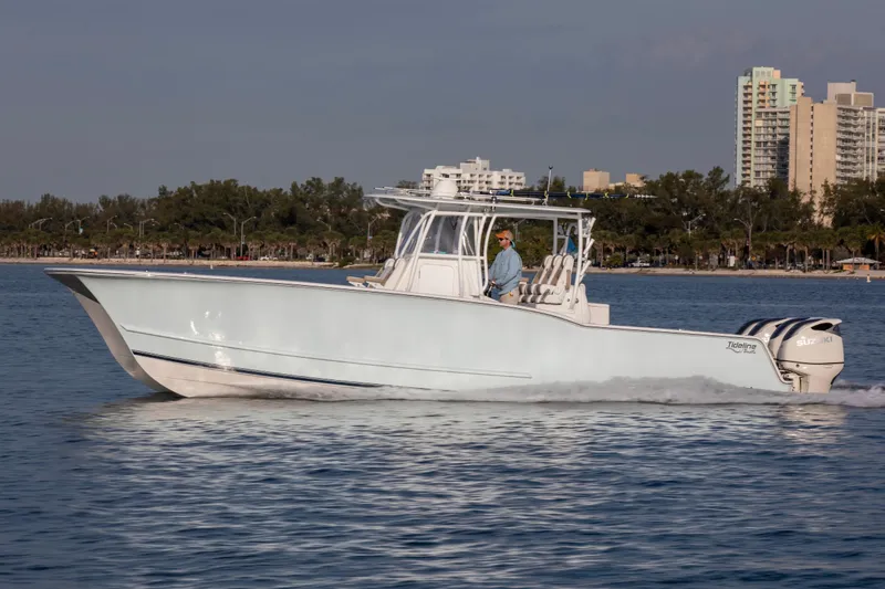 Slide: The Image of 2026 Tideline 365 Offshore boat cruising on calm water near a cityscape. - 7