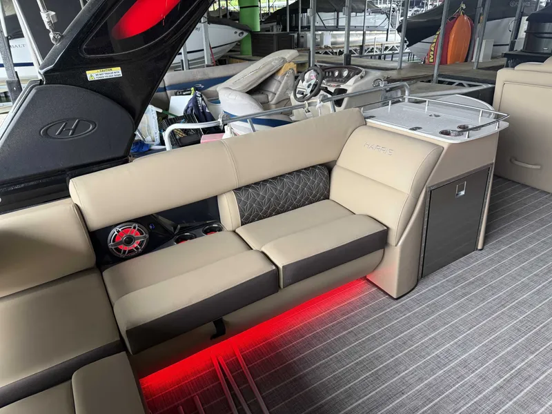 Slide: The Image of Interior of a 2023 Harris 270GM boat with luxurious seating and red lighting. - 32