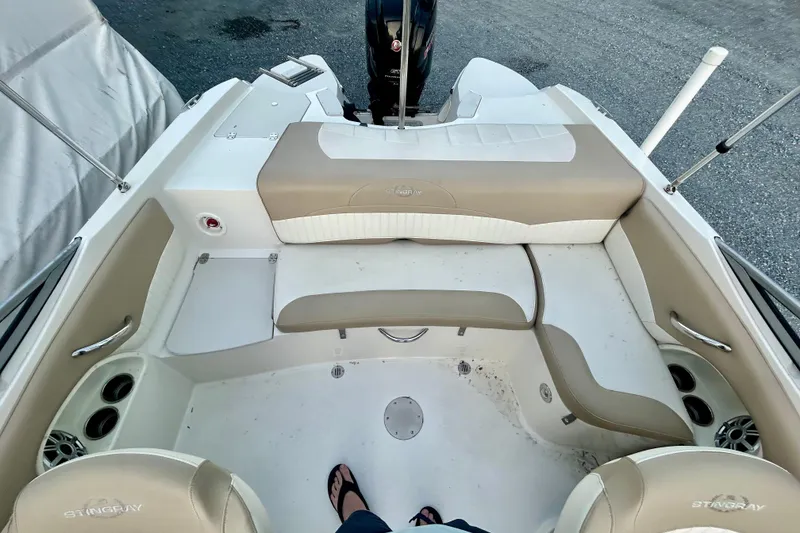 Slide: The Image of 2017 Stingray 204 LR boat interior with beige seating and cup holders. - 5