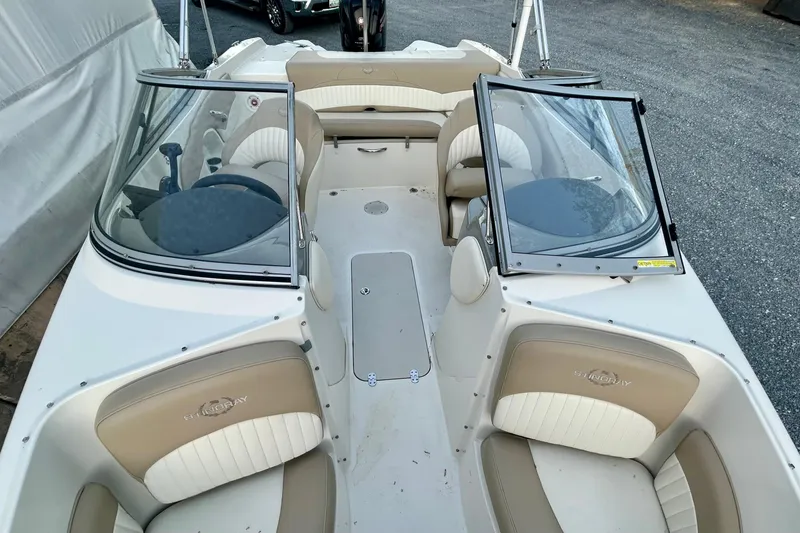 Slide: The Image of 2017 Stingray 204 LR boat interior with beige and white seating, open windshield, and steering wheel. - 6
