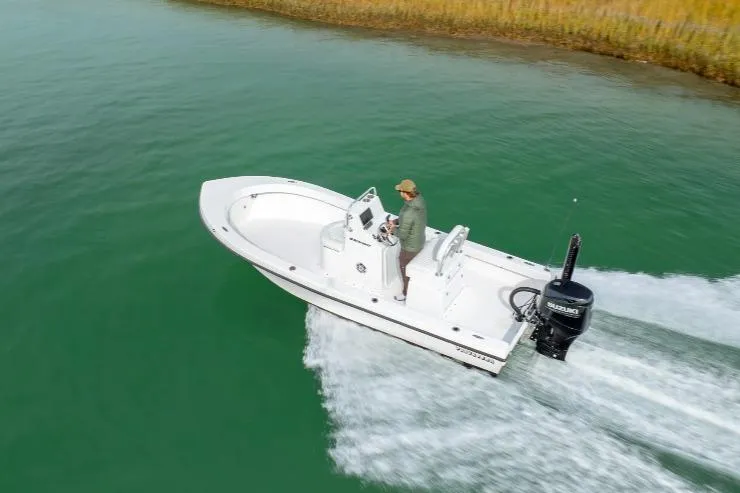 Slide: The Image of 2026 Privateer 18 Retriever boat cruising on green water with driver. - 10