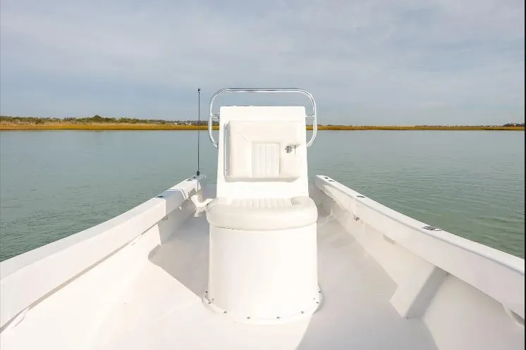 Slide: The Image of 2026 Privateer 18 Retriever boat on calm water, featuring a central seat and open deck. - 6