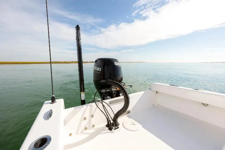 Slide: The Image of 2026 Privateer 18 Retriever boat with Suzuki outboard motor on calm water. - 9