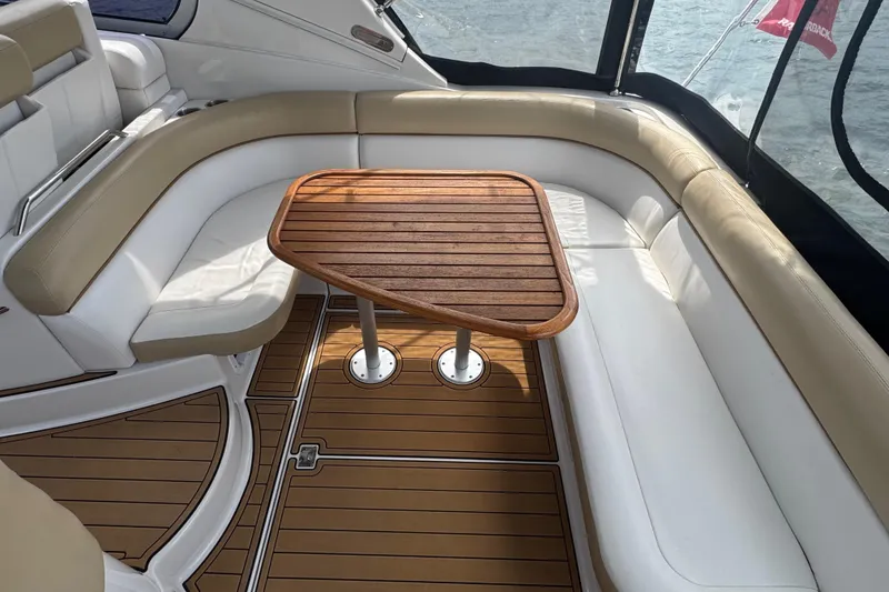 Slide: The Image of 2009 Four Winns V358 boat interior with white seating and wooden table. - 14