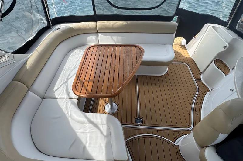 Slide: The Image of 2009 Four Winns V358 boat interior with wooden table and cushioned seating. - 15