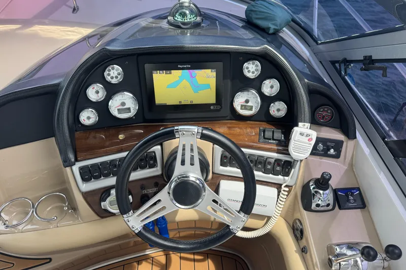 Slide: The Image of 2009 Four Winns V358 boat dashboard with steering wheel, gauges, and navigation system. - 18