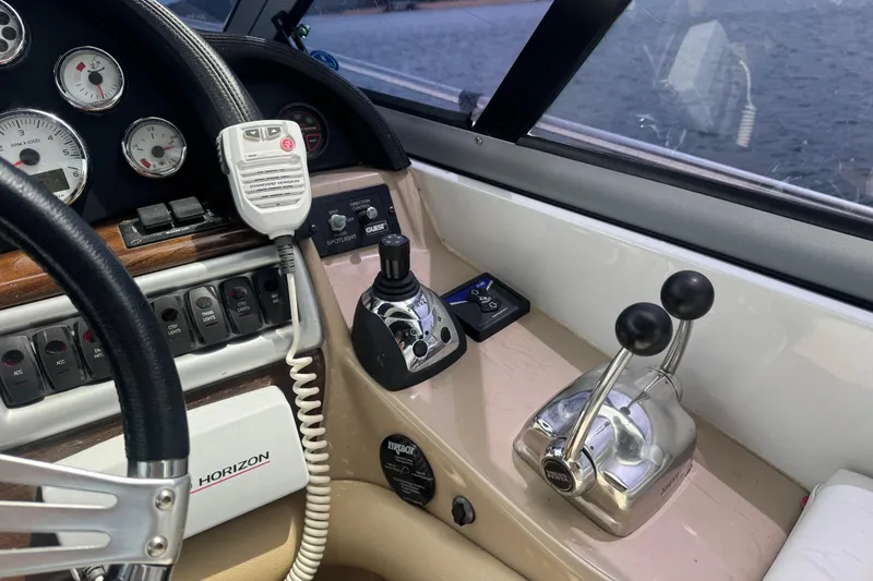 Slide: The Image of 2009 Four Winns V358 boat dashboard with controls, gauges, and steering wheel. - 19