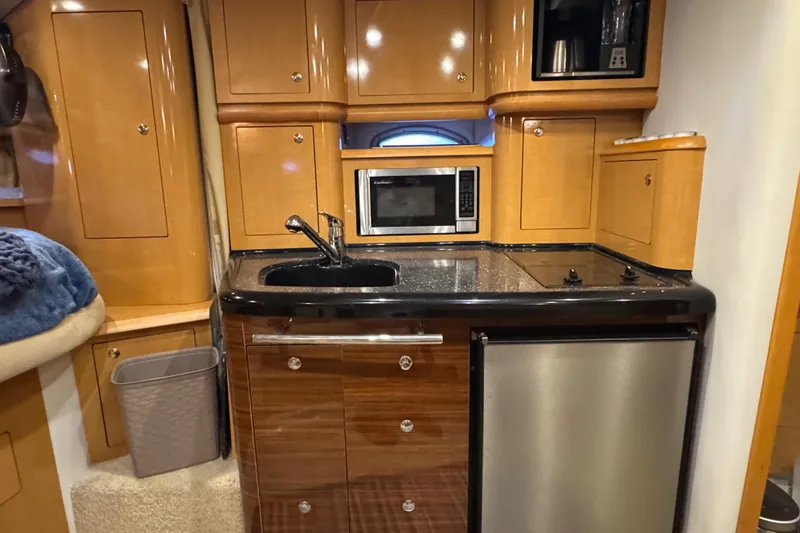 Slide: The Image of 2009 Four Winns V358 yacht interior kitchen with microwave, sink, and mini fridge. - 29