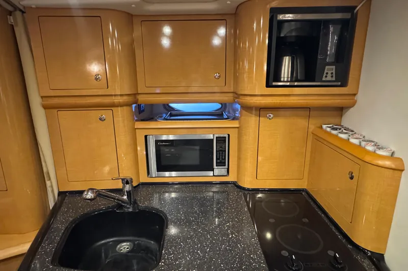 Slide: The Image of Luxurious 2009 Four Winns V358 yacht kitchen with microwave, coffee maker, and sleek cabinetry. - 30