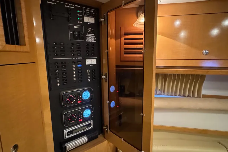 Slide: The Image of Electrical control panel inside 2009 Four Winns V358 boat cabin, featuring modern wood cabinetry. - 36