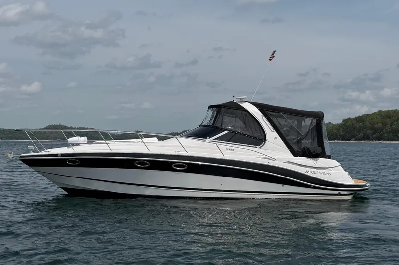 Slide: The Image of 2009 Four Winns V358 boat on calm water, featuring sleek design and black canopy. - 5