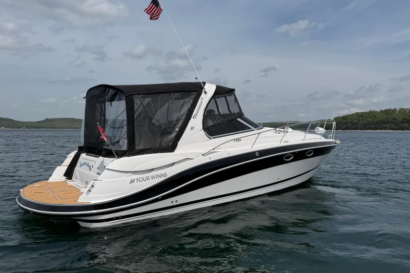 Slide: The Image of 2009 Four Winns V358 boat cruising on a lake under a cloudy sky. - 7