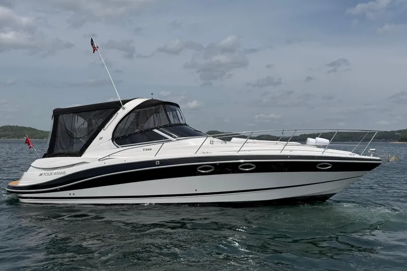 Slide: The Image of 2009 Four Winns V358 boat on water, featuring sleek design and black canopy. - 8