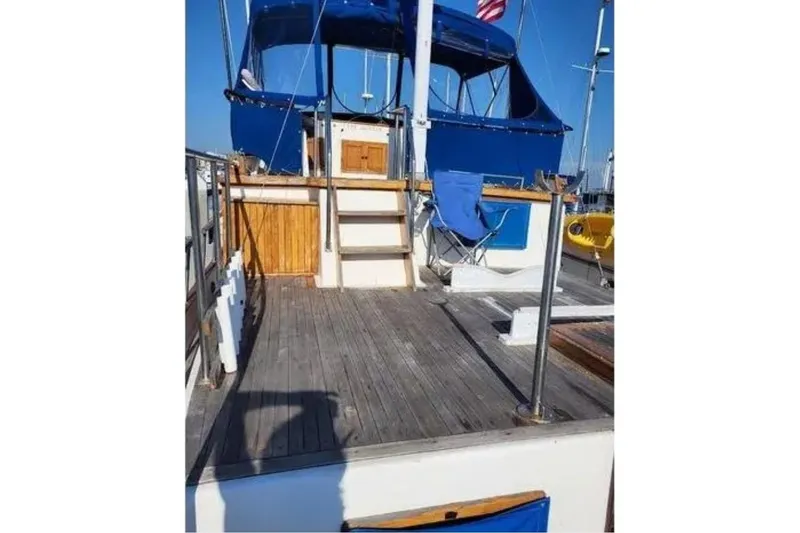 Slide: The Image of 1981 Marine Trader Trunk Cabin boat deck with blue canopy and wooden accents. - 11