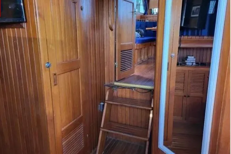 Slide: The Image of 1981 Marine Trader Trunk Cabin interior with wooden paneling and cozy seating area. - 6