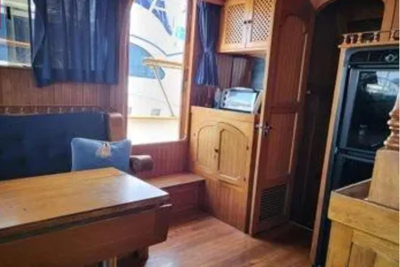 Slide: The Image of 1981 Marine Trader Trunk Cabin interior with wooden furnishings and cozy seating area. - 7