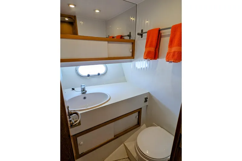 Slide: The Image of Compact bathroom in 1990 Neptunus Sedan 148 yacht with sink, toilet, and orange towels. - 10