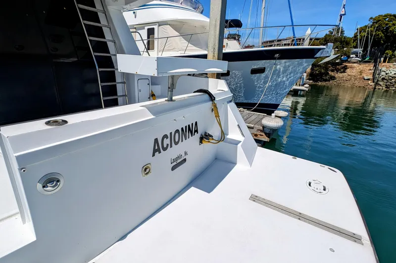 Slide: The Image of 1990 Neptunus Sedan 148 yacht docked at marina, featuring "ACIONNA" name on stern. - 13