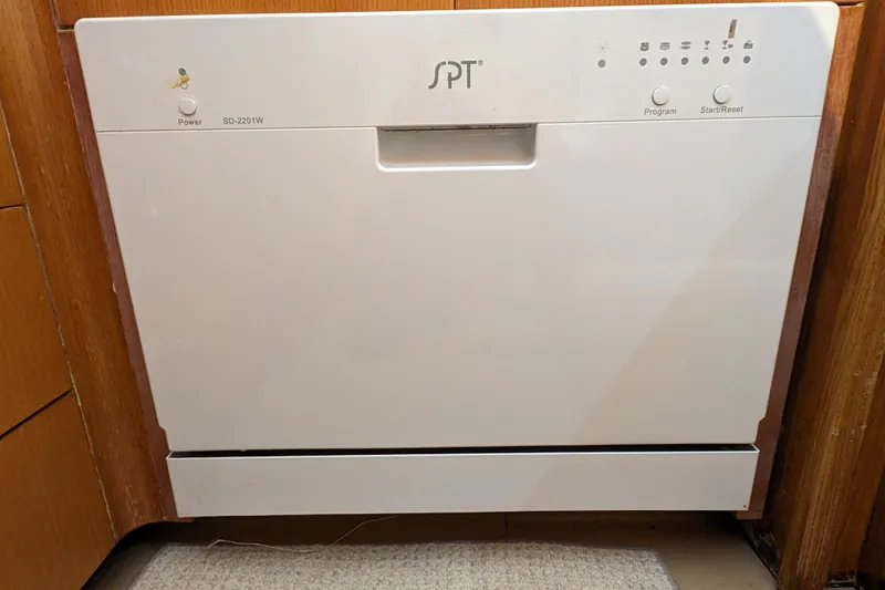 Slide: The Image of White SPT countertop dishwasher, model SD-2201W, integrated into wooden cabinetry. - 14