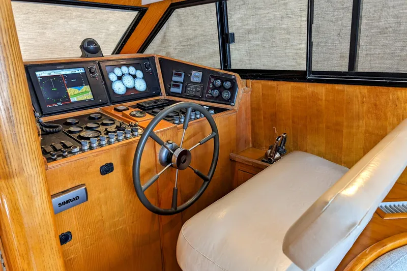 Slide: The Image of 1990 Neptunus Sedan 148 helm with wooden dashboard, steering wheel, and navigation instruments. - 21