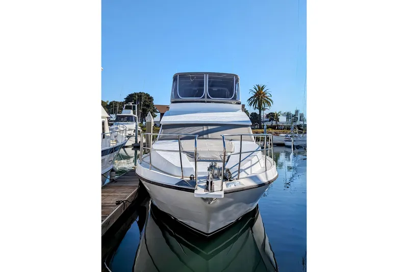 Slide: The Image of 1990 Neptunus Sedan 148 yacht docked in a marina under clear blue skies. - 24
