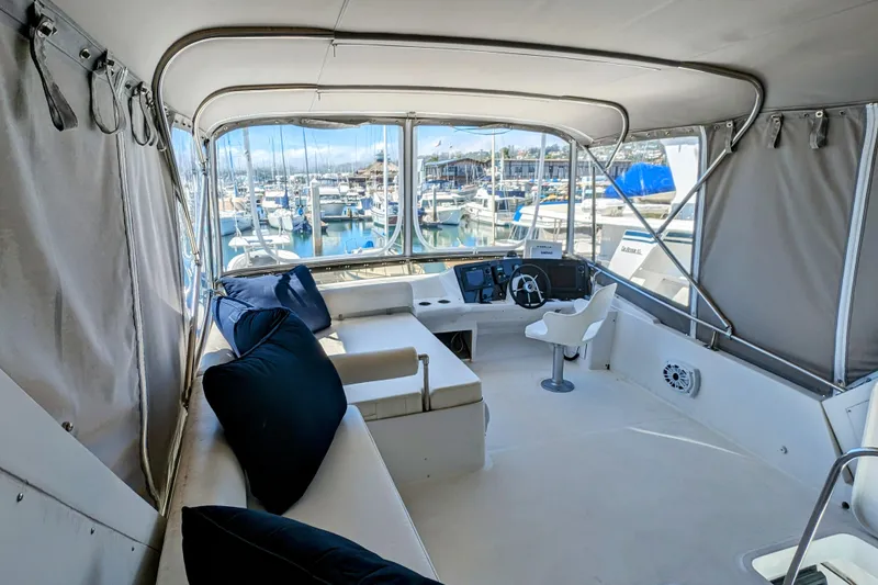Slide: The Image of Interior of 1990 Neptunus Sedan 148 yacht with marina view, featuring helm and seating area. - 29
