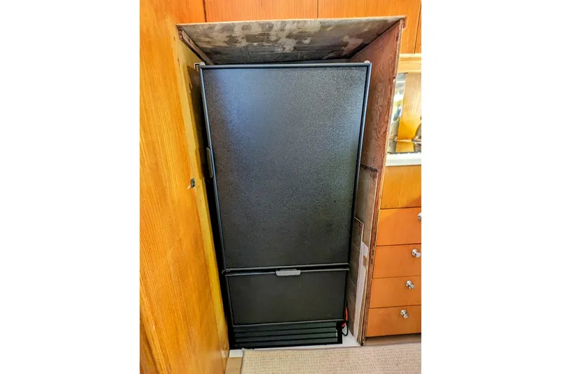 Slide: The Image of Black refrigerator in wooden cabinet, Neptunus Sedan 148, 1990 model. - 32