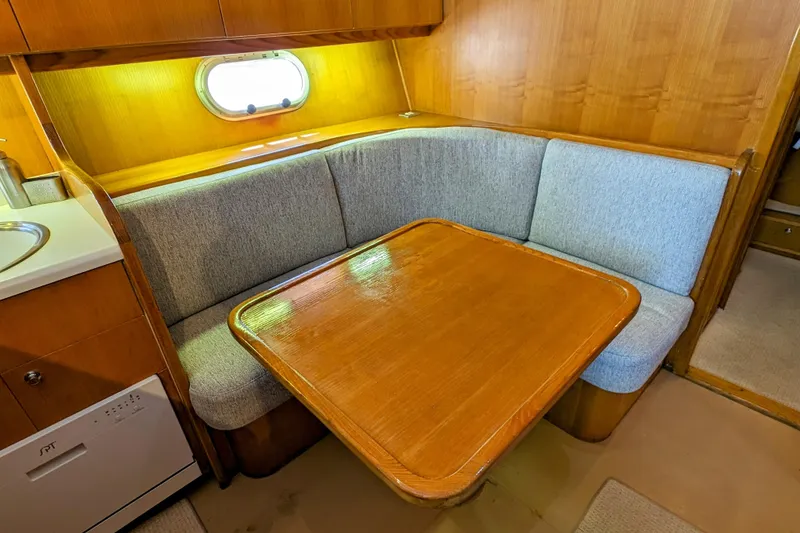 Slide: The Image of Cozy dining area in 1990 Neptunus Sedan 148 yacht with wooden table and cushioned seating. - 35