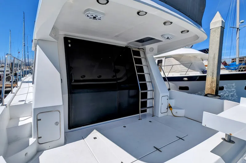 Slide: The Image of 1990 Neptunus Sedan 148 yacht deck with ladder and sleek design in marina setting. - 4