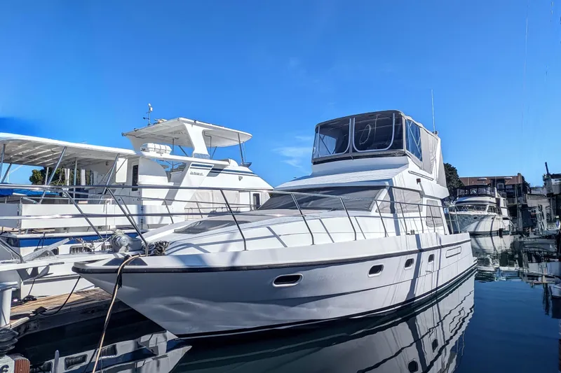 Slide: The Image of 1990 Neptunus Sedan 148 yacht docked in a marina under clear blue skies. - 40