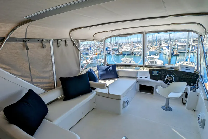 Slide: The Image of Luxurious 1990 Neptunus Sedan 148 yacht interior with marina view, featuring plush seating and helm. - 5