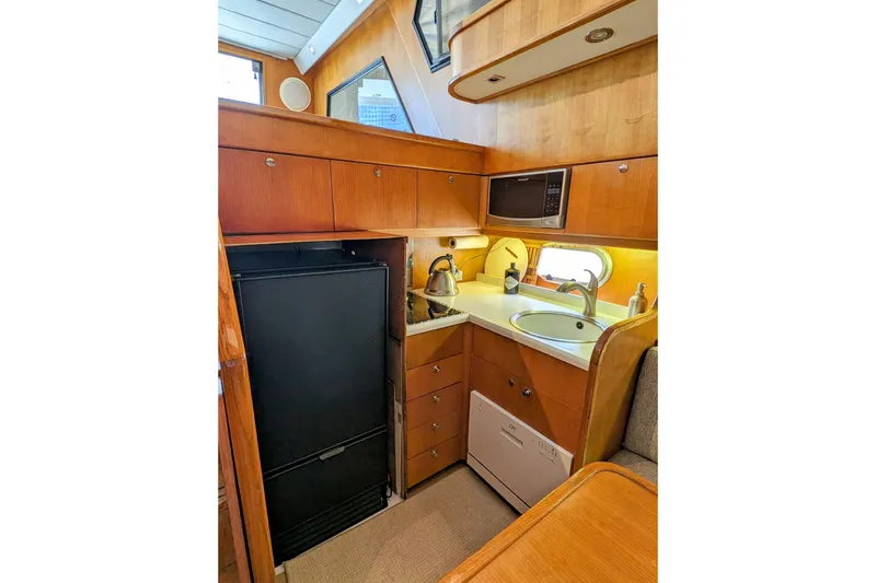 Slide: The Image of Compact kitchen in 1990 Neptunus Sedan 148 yacht with wood cabinetry and modern appliances. - 9