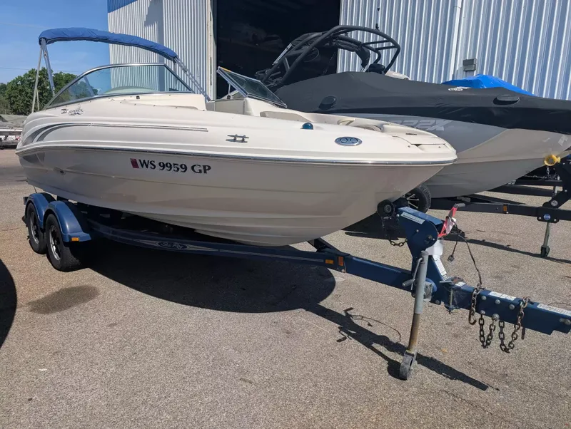 The Image of 2004 Sea Ray 200 Sundeck boat on trailer outdoors. - 1