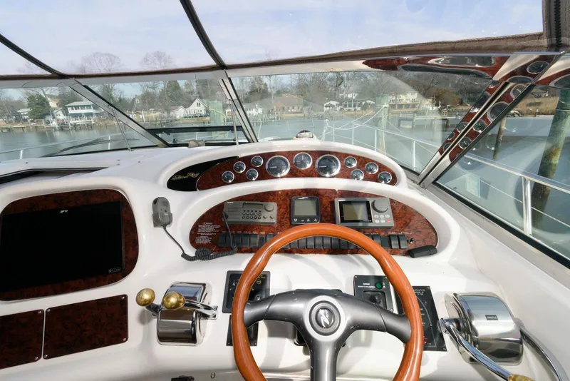 Slide: The Image of 1999 Sea Ray 380 Sundancer helm with wood accents and modern controls. - 10