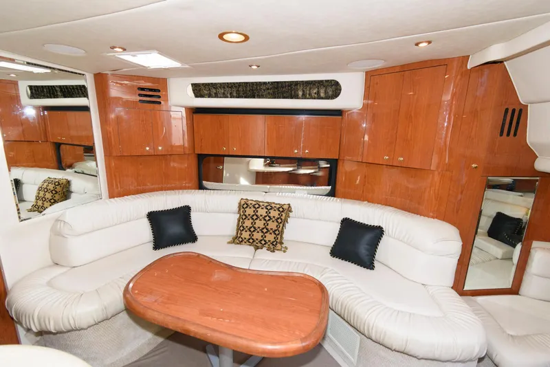 Slide: The Image of Interior of 1999 Sea Ray 380 Sundancer with plush seating and wooden cabinetry. - 14