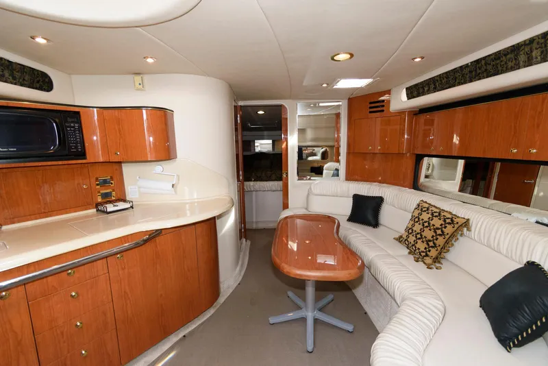 Slide: The Image of Interior of 1999 Sea Ray 380 Sundancer yacht with elegant wood cabinetry and plush seating. - 16