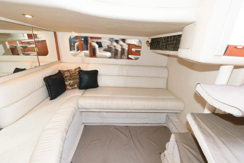 Slide: The Image of Interior of 1999 Sea Ray 380 Sundancer with white seating and decorative pillows. - 18