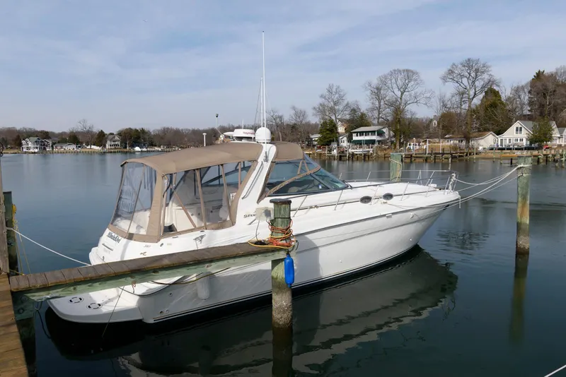 Slide: The Image of 1999 Sea Ray 380 Sundancer yacht docked in a serene marina setting. - 2