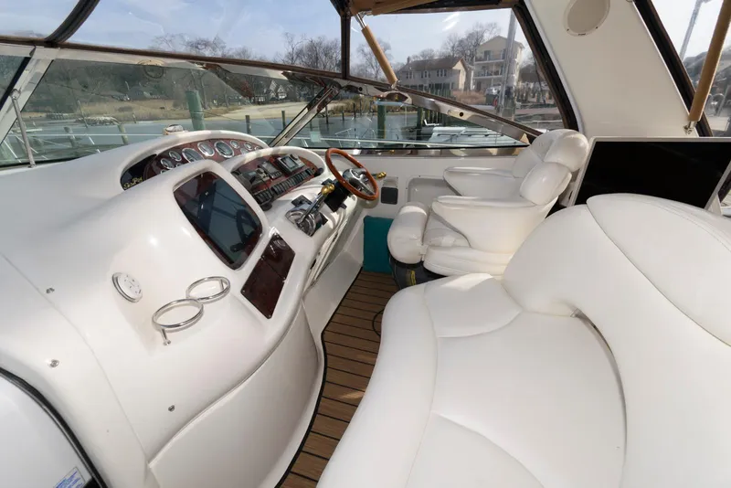 Slide: The Image of 1999 Sea Ray 380 Sundancer cockpit with white seating and modern controls. - 8
