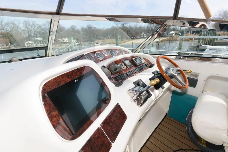 Slide: The Image of 1999 Sea Ray 380 Sundancer helm with wood accents and modern controls. - 9