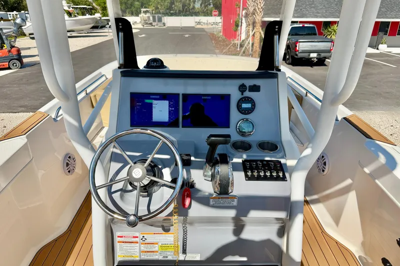 Slide: The Image of 2023 Bayliner Trophy T24CC boat dashboard with steering wheel and navigation controls. - 10