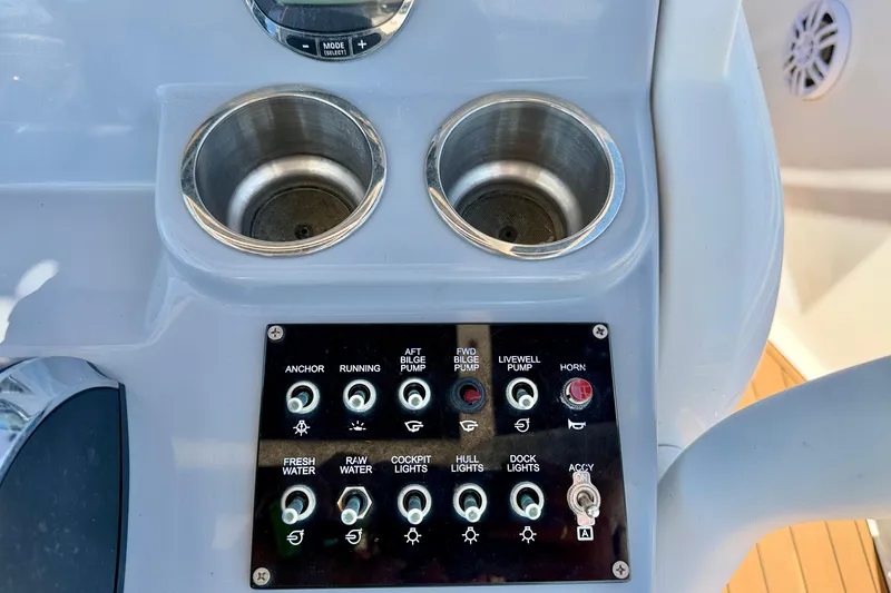 Slide: The Image of Control panel of 2023 Bayliner Trophy T24CC boat with cup holders and switches. - 12