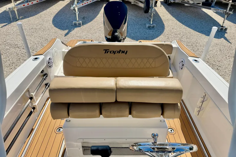 Slide: The Image of 2023 Bayliner Trophy T24CC boat interior with tan seating and wood flooring. - 18