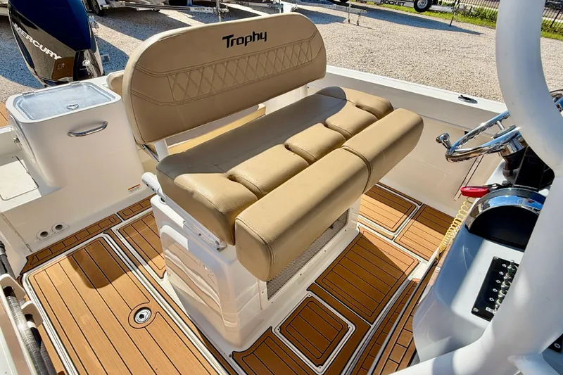 Slide: The Image of 2023 Bayliner Trophy T24CC boat interior with tan seating and wood-patterned flooring. - 19