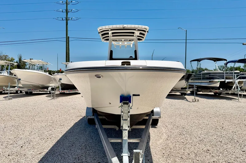 Slide: The Image of 2023 Bayliner Trophy T24CC boat on trailer in sunny dealership lot. - 2