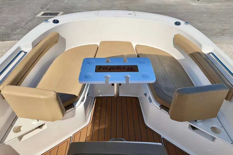 Slide: The Image of 2023 Bayliner Trophy T24CC boat interior with cushioned seating and table. - 22