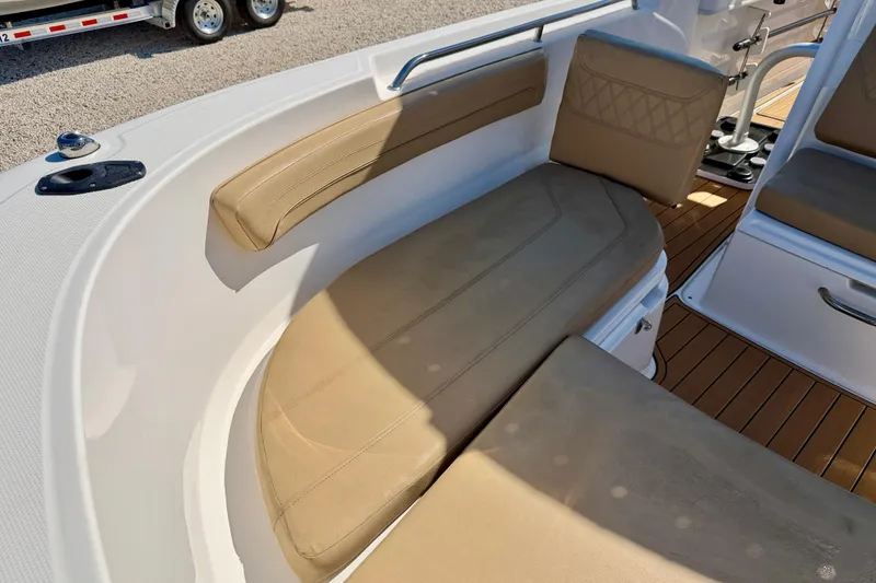 Slide: The Image of 2023 Bayliner Trophy T24CC boat interior with beige cushioned seating and wood-style flooring. - 23