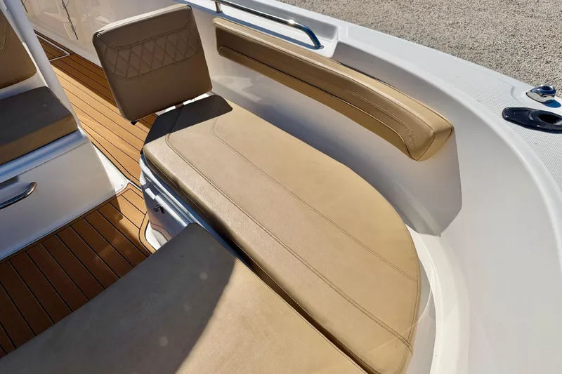 Slide: The Image of 2023 Bayliner Trophy T24CC boat interior with tan seating and wood flooring. - 24
