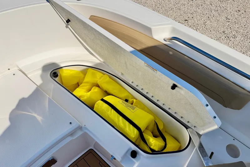 Slide: The Image of Storage compartment with yellow life jackets on a 2023 Bayliner Trophy T24CC boat. - 25